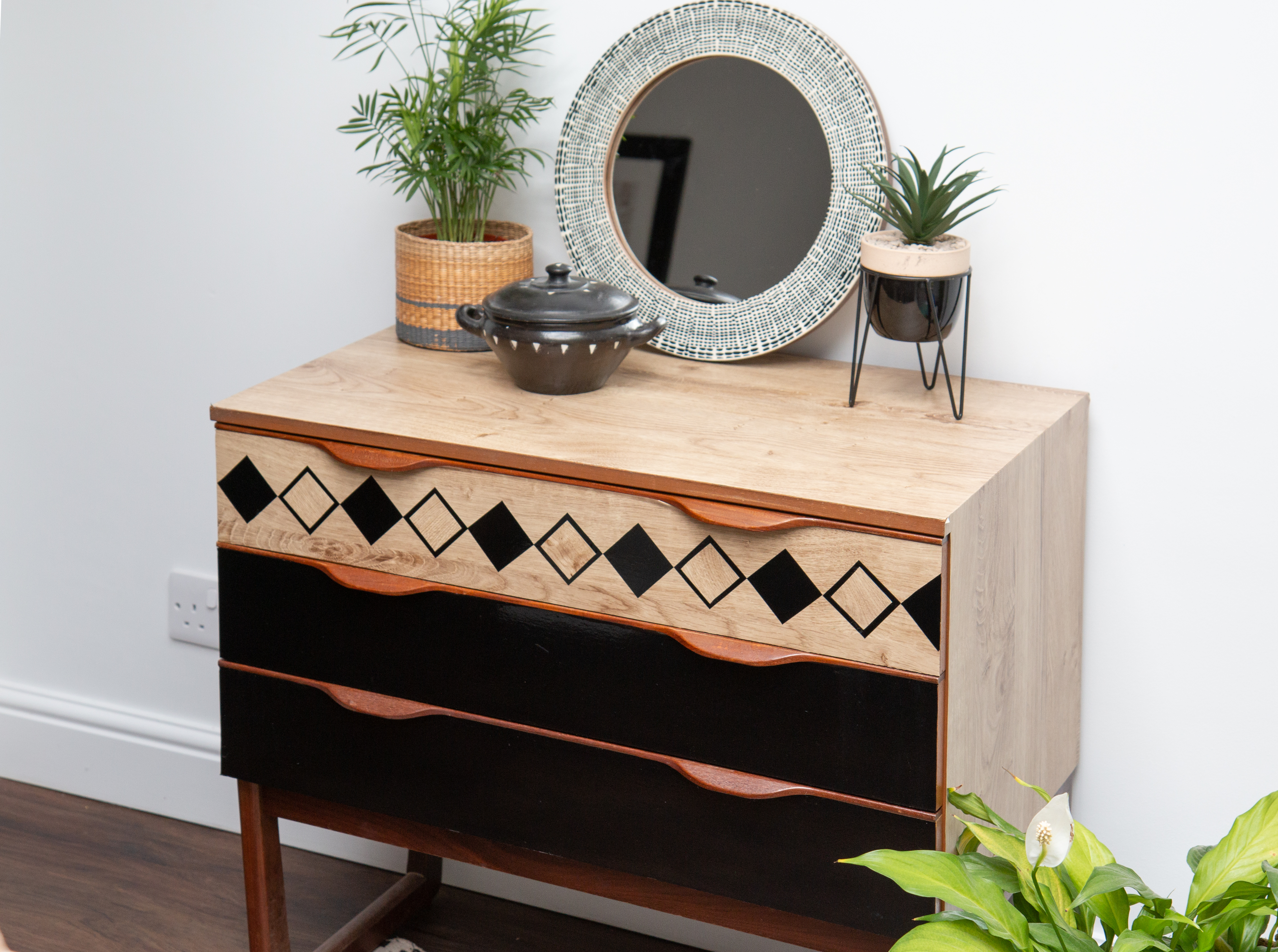 Chest of drawers covered with d-c-fix® adhesive films in a boho look with wood effect and decorative elements in black.